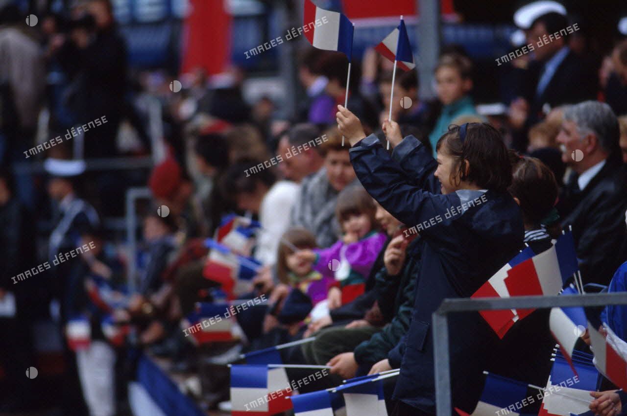 La foule présente brandit des petits drapeaux français lors du défilé militaire au retour de la division Daguet à Toulon.