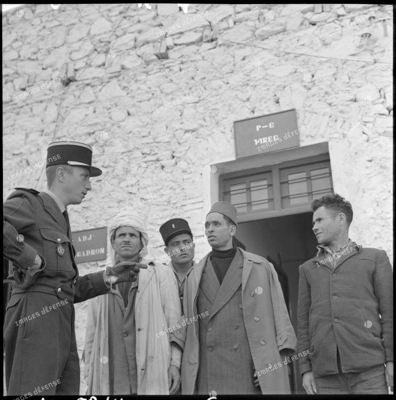 Un officier français discute avec trois harkis lors de leur engagement à Bou-Saâda.