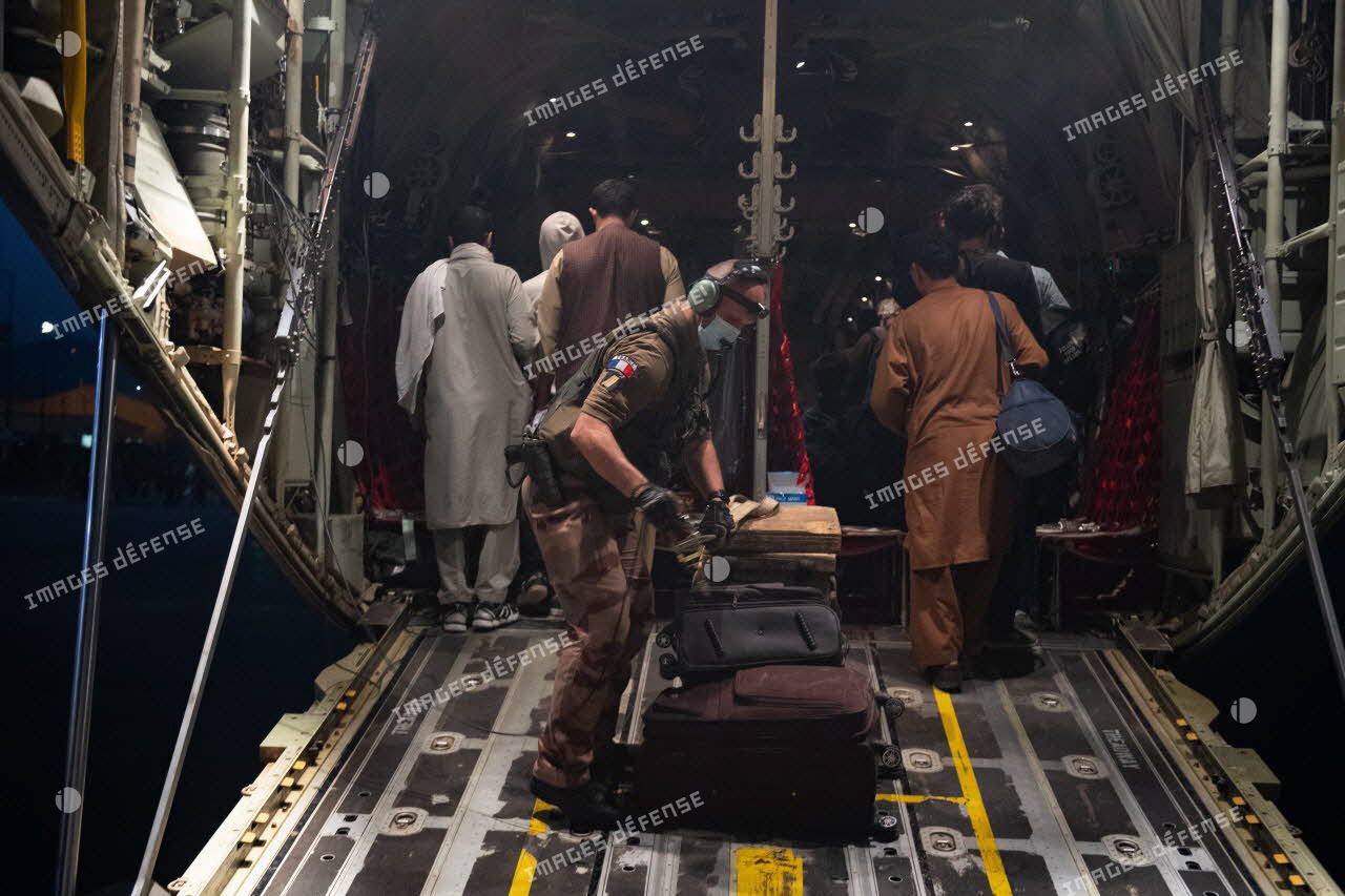 Un soldat encadre l'évacuation de ressortissants à bord d'un avion-cargo Lockheed Hercules C-130 à Kaboul, en Afghanistan.