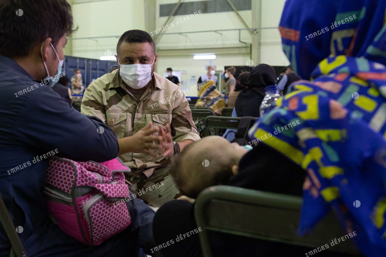 Un soldat discute avec des réfugiés afghans à Al Dhafra, aux Emirats arabes unis.