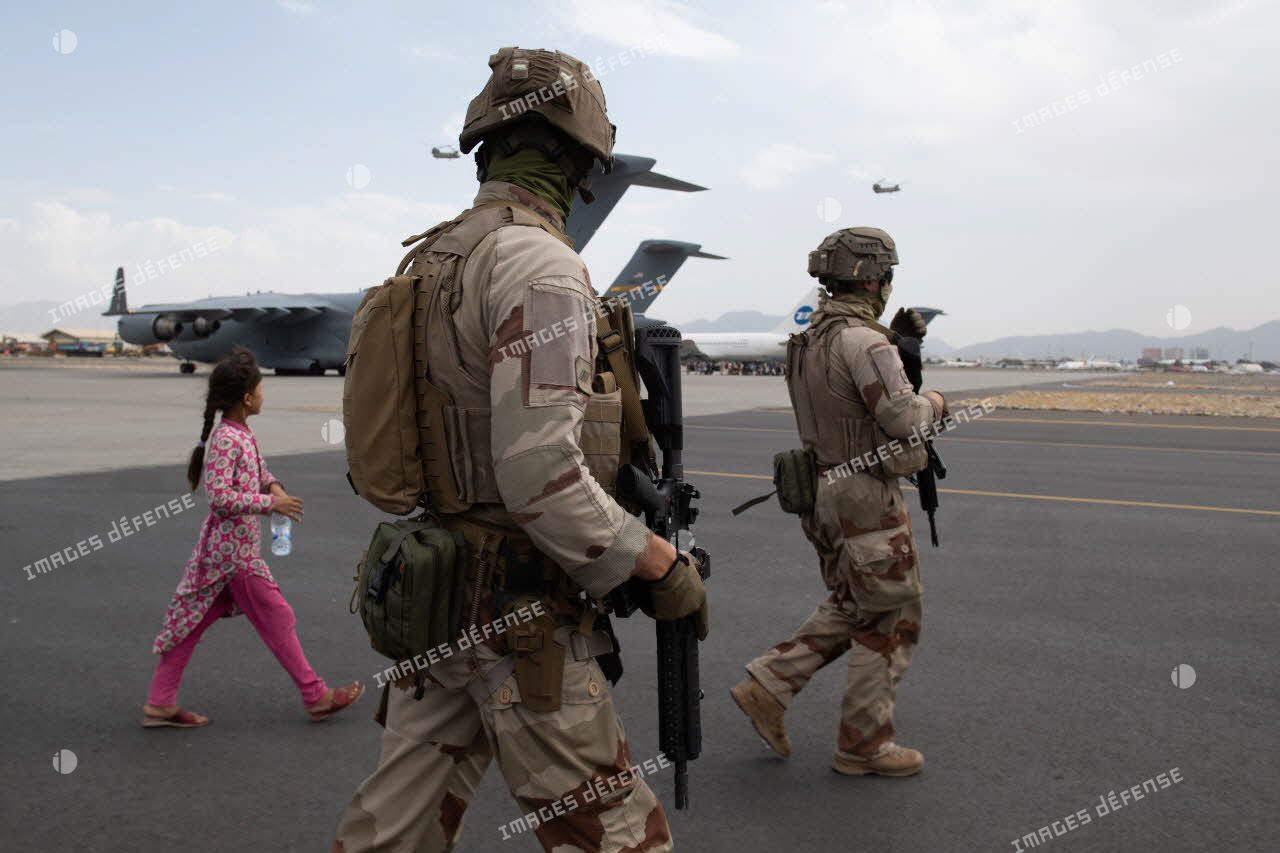 Des soldats escortent des ressortissants évacués à l'aéroport de Kaboul, en Afghanistan.