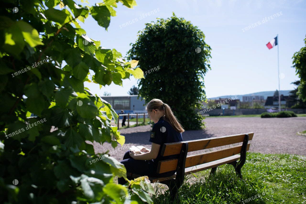 Une collégienne profite de sa récréation pour lire sur un banc dans la cour du lycée militaire d'Autun.