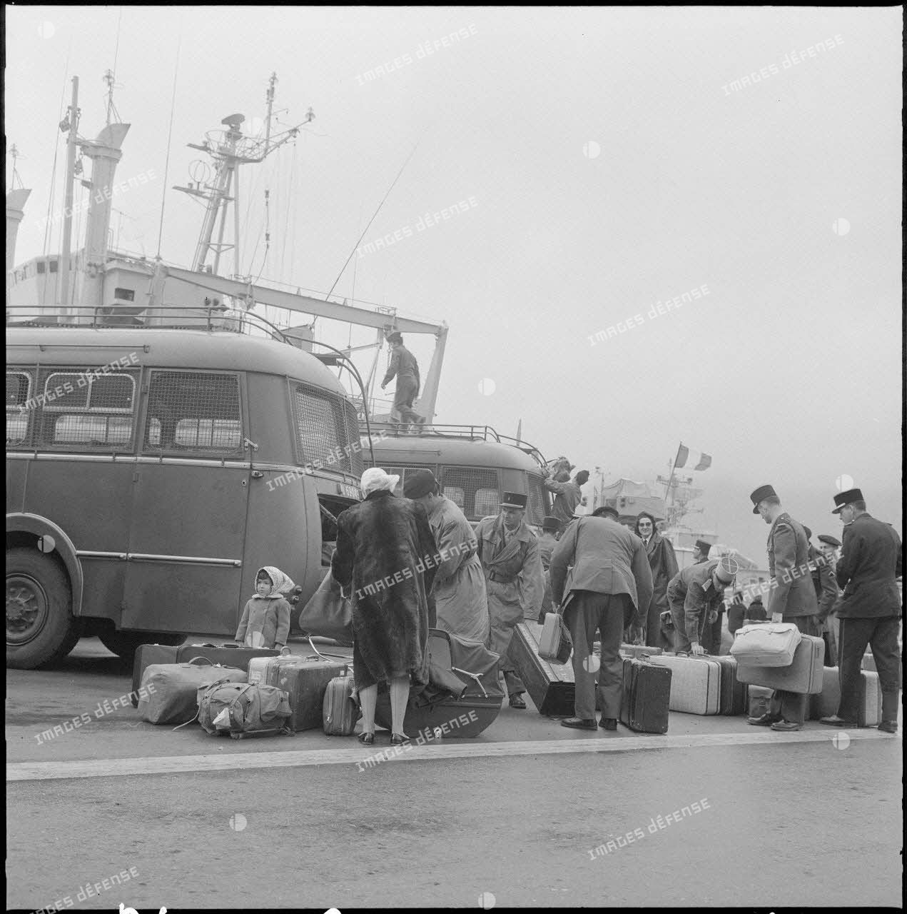 Familles partant du port d'Oran pour la France, aidées par des soldats.