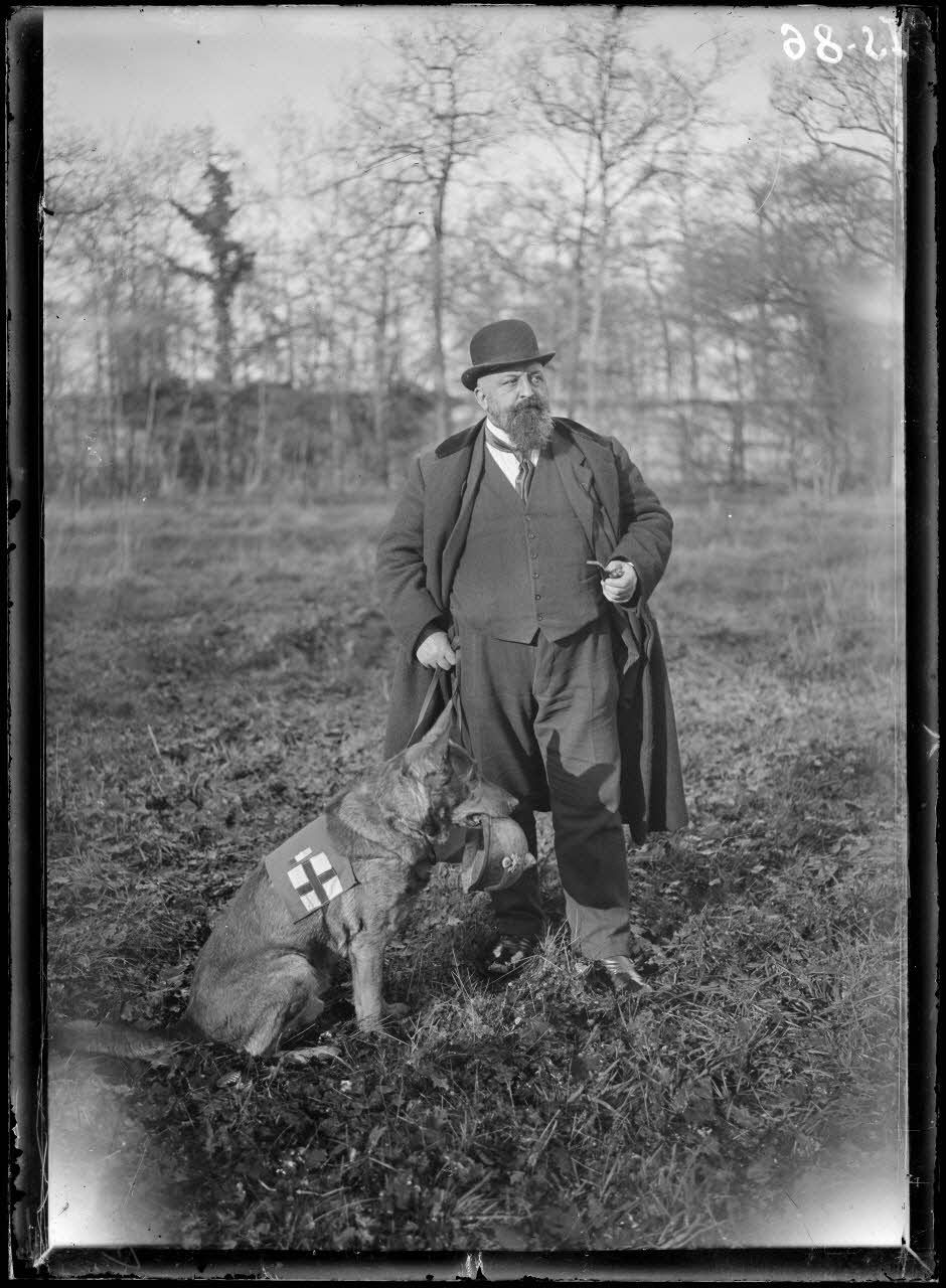 Maison-Lafitte, la société nationale du chien sanitaire et de guerre. M. Lepel Boutet, président fondateur de la société des chiens sanitaires et de guerre, avec le chien champion "Rolph". [légende d'origine]