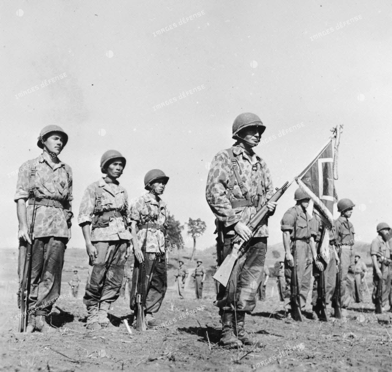 Lors d'une prise d'armes à Na San, le chef de bataillon Bonnigal, commandant le 3e bataillon de parachutistes coloniaux (3e BPC) porte le fanion de son unité.