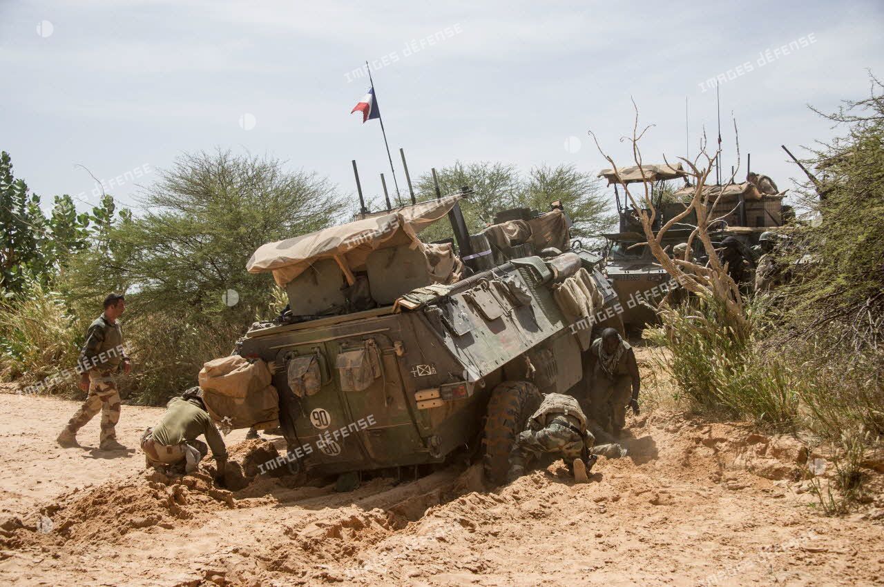 Des soldats des forces armées maliennes (FAMa) dégagent un véhicule de l’avant blindé (VAB) ensablé dans un oued lors du franchissement du fleuve Niger.