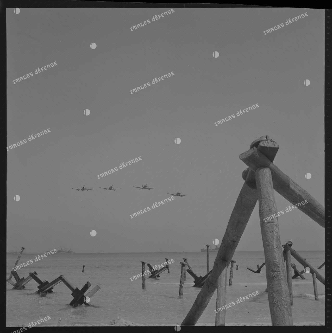 Sur le tournage du film Le jour le plus long. Passage des avions chasseurs américains au-dessus de la plage du débarquement.