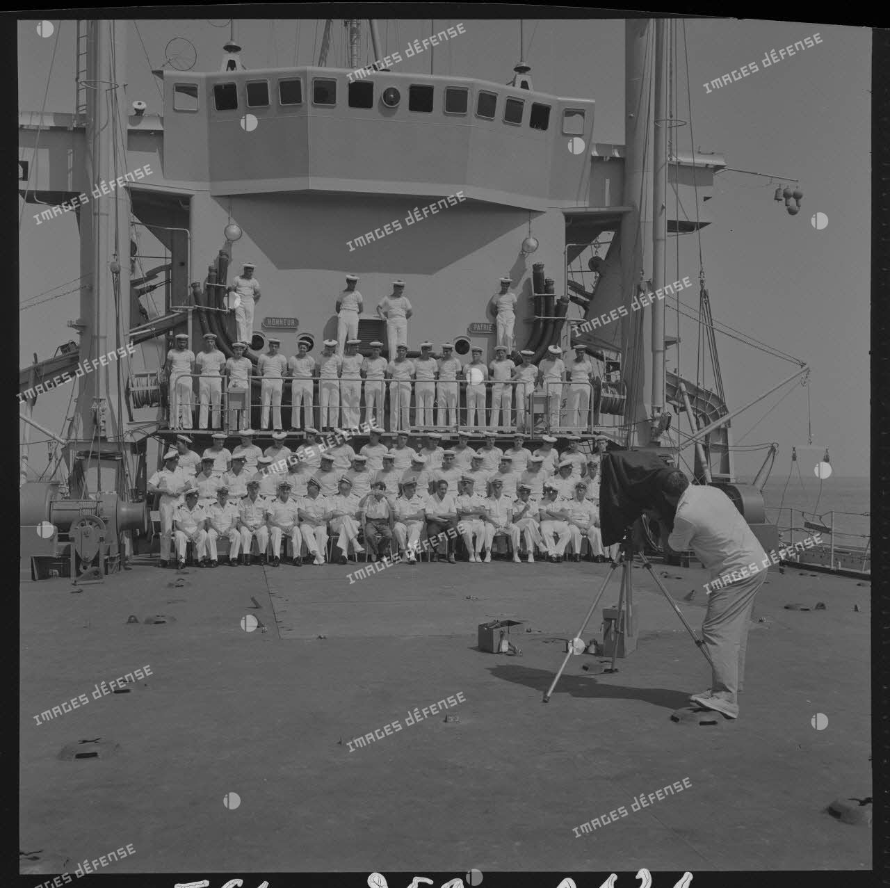 Sur le tournage du film Le jour le plus long. Pour remercier les marins du bâtiment de débarquement de chars (BDC) Argens (L9003), une photographie de groupe leur est offerte par Darryl Zanuck, producteur du film. Ici, le photographe du film, André Berlincourt, pendant la prise de vues.