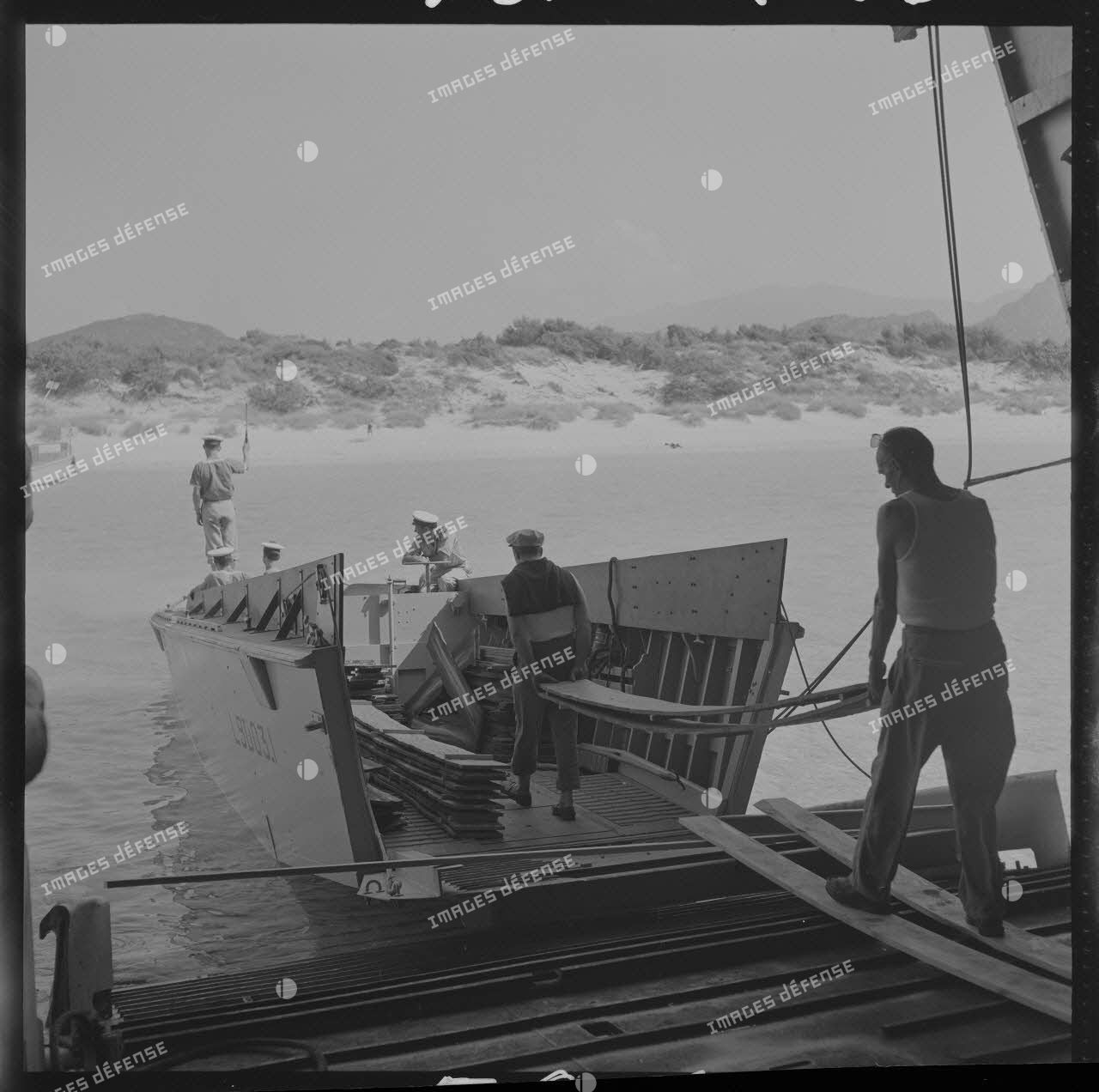 Sur le tournage du film Le jour le plus long. Le matériel (décors) est transporté sur la plage par un engin de débarquement (LCVP L9003.1) de l'Argens.