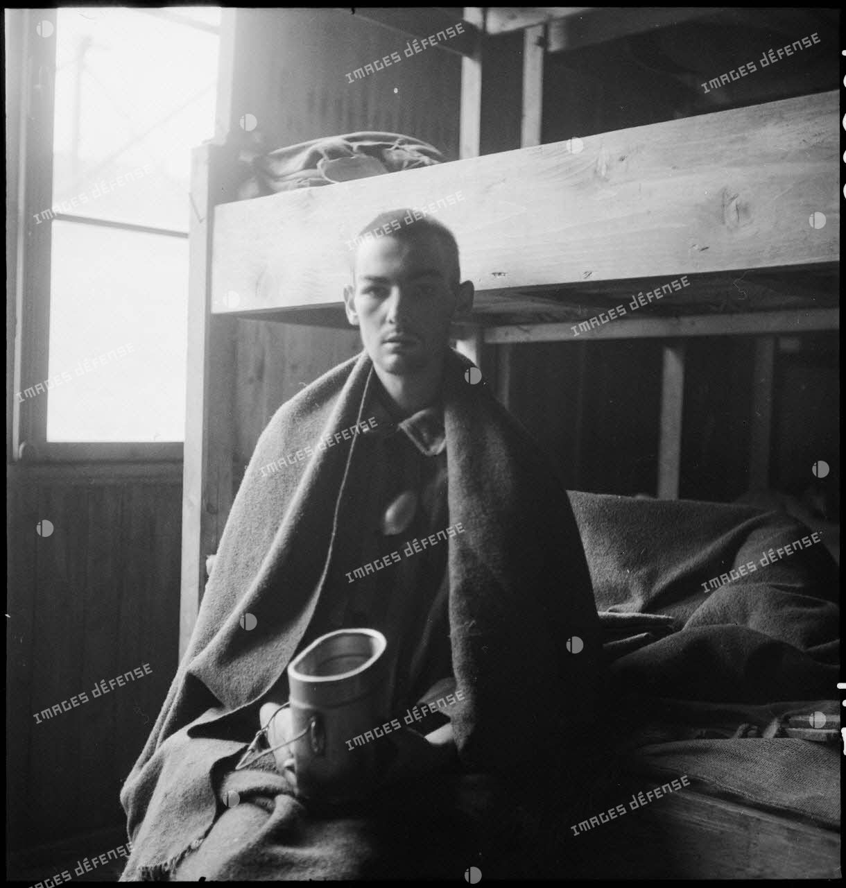 Portrait d'un déporté dans un baraquement du camp de Vaihingen récemment libéré.
