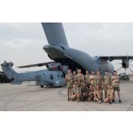 Photographie de groupe de l'équipe du transit aérien et de mécaniciens lors du déchargement d'un hélicoptère Caracal EC 725 du DetHM (détachement d'hélicoptères de manoeuvre), livré par l'ATT (avion de transport tactique) A400 M de l'escadron de transport 01.061 Touraine de la BA 123 (base aérienne), sur la BA 172 Sergent-chef Adji Kossei à l'aéroport de N'Djamena.
