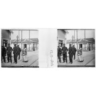 [Groupe d'officiers devant une gare, deux fillettes à leur côté].