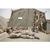 Un auxiliaire sanitaire encadre un stage sur la mise en place d'un garot tourniquet auprès de soldats du 13e bataillon de chasseurs alpins (BCA) à Tombouctou, au Mali.