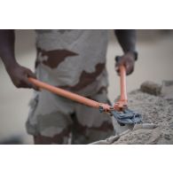 Un sapeur du 19e régiment du génie (RG) procède à la destruction d'un mirador pour la consolidation de l'enceinte de la base de Tombouctou, au Mali.