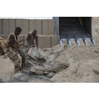 Des sapeurs du 19e régiment du génie (RG) procèdent à la destruction d'un mirador à l'aide d'une pelle hydraulique 317 pour la consolidation de l'enceinte de la base de Tombouctou, au Mali.