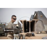 Un sapeur du 19e régiment du génie (RG) aidé par des ouvriers civils décharge du matériel pour la consolidation de l'enceinte de la base de Tombouctou, au Mali.