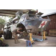 Le caporal Florian du 13e bataillon de chasseurs alpins (BCA) effectue la remise en état du système de roulage d'un véhicule de l'avant blindé (VAB) à Tombouctou, au Mali.