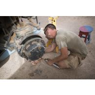 Le caporal Florian du 13e bataillon de chasseurs alpins (BCA) effectue la remise en état du système de roulage d'un véhicule de l'avant blindé (VAB) à Tombouctou, au Mali.