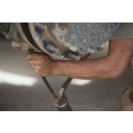 Le caporal Florian du 13e bataillon de chasseurs alpins (BCA) effectue la remise en état du système de roulage d'un véhicule de l'avant blindé (VAB) à Tombouctou, au Mali.