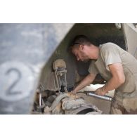 Le caporal Florian du 13e bataillon de chasseurs alpins (BCA) effectue la remise en état du système de roulage d'un véhicule de l'avant blindé (VAB) à Tombouctou, au Mali.