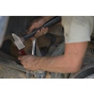 Le caporal Florian du 13e bataillon de chasseurs alpins (BCA) effectue la remise en état du système de roulage d'un véhicule de l'avant blindé (VAB) à Tombouctou, au Mali.