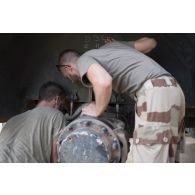 Le caporal Florian et le sergent-chef Eric du 13e bataillon de chasseurs alpins (BCA) effectuent la remise en état du système de roulage d'un véhicule de l'avant blindé (VAB) à Tombouctou, au Mali.