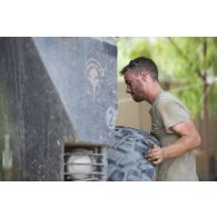 Le sergent-chef Eric du 13e bataillon de chasseurs alpins (BCA) effectue la remise en état du système de roulage d'un véhicule de l'avant blindé (VAB) à Tombouctou, au Mali.
