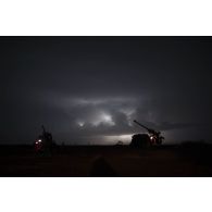Mise en batterie de deux camions équipés d'un système d'artillerie (CAESAR) du 93e régiment d'artillerie de montagne (RAM) sous un orage sur le pas de tir de Gao, au Mali.
