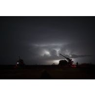 Mise en batterie de deux camions équipés d'un système d'artillerie (CAESAR) du 93e régiment d'artillerie de montagne (RAM) sous un orage sur le pas de tir de Gao, au Mali.