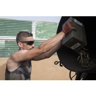 Un munitionnaire dépose les déchets de cartouches à éliminer dans le four du dépôt des munitions de Gao, au Mali.