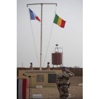 Le colonel Pierre Verborg du 3e régiment d'hélicoptères de combat (RHC) salue lever des couleurs pour la cérémonie du 14 juillet à Gao, au Mali.