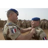 Le colonel Pierre Verborg du 3e régiment d'hélicoptères de combat (RHC) remet la médaille militaire à un sous-officier du détachement aéromobile pour la cérémonie du 14 juillet à Gao, au Mali.