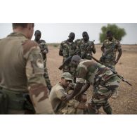 Le médecin des armées Benoît et l'auxiliaire sanitaire Iliès encadrent des stagiaires nigériens pour une formation de secourisme au combat dans la région d'Inatès, au Niger.