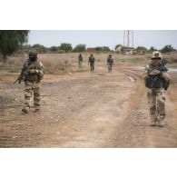 Le caporal-chef Luke du commando parachutiste de l'air n°20 (CPA 20) sécurise le périmètre de la reconnaissance menée par le lieutenant Robert des actions civilo-militaires (CIMIC) à Inatès, au Niger.