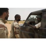 Les caporaux-chefs Luke et Yann du commando parachutiste de l'air n°20 (CPA 20) discutent avec un soldat nigérien dans la région d'Inatès, au Niger.