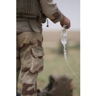 Un auxiliaire sanitaire applique une perfusion auprès d'un blessé pour son évacuation près d'Ayorou, au Niger.