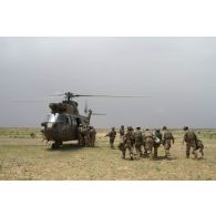 L'équipe médicale de la force de réaction rapide (FRR) transporte un soldat blessé vers un hélicoptère Puma SA-330B pour son évacuation près d'Ayorou, au Niger.