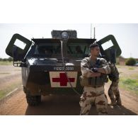 Des soldats d'une équipe médicale attendent autour de leur véhicule de l'avant blindé sanitaire (VAB SAN) l'arrivée des soldats nigériens pour partir en mission à Tillabéri, au Niger.