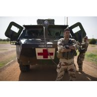 Des soldats d'une équipe médicale attendent autour de leur véhicule de l'avant blindé sanitaire (VAB SAN) l'arrivée des soldats nigériens pour partir en mission à Tillabéri, au Niger.