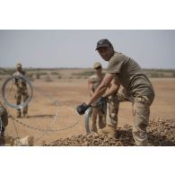 Des sapeurs du 2e régiment étranger de génie (REG) et du 19e régiment du génie (RG) installent du fil de fer barbelé autour du camp de Labbezanga, au Niger.