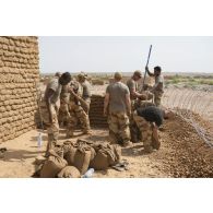 Des sapeurs du 2e régiment étranger de génie (REG) et du 19e régiment du génie (RG) installent des sacs à terre autour du camp de Labbezanga, au Niger.