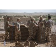 Des sapeurs du 2e régiment étranger de génie (REG) et du 19e régiment du génie (RG) installent des sacs à terre autour du camp de Labbezanga, au Niger.
