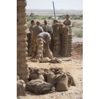 Des sapeurs du 2e régiment étranger de génie (REG) et du 19e régiment du génie (RG) installent des sacs à terre autour du camp de Labbezanga, au Niger.