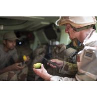 Le médecin des armées Benoît et l'auxiliaire sanitaire Iliès prennent leur repas à bord de leur véhicule de l'avant blindé sanitaire (VAB SAN) lors de la halte d'un convoi dans la région d'Ayorou, au Niger.