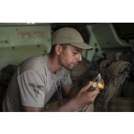 L'auxiliaire sanitaire Iliès prend son repas à bord de son véhicule de l'avant blindé sanitaire (VAB SAN) lors de la halte d'un convoi dans la région d'Ayorou, au Niger.