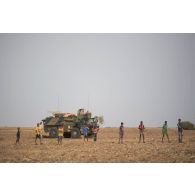 Des enfants entourent un véhicule de l'avant blindé (VAB) de la compagnie de commandement et de transmissions (CCT) de la 2e brigade blindée (BB) à Inatès, au Niger.