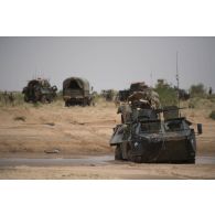 Un camion porteur polyvalent lourd de dépannage (PPLD) tracte un véhicule de l'avant blindé (VAB) enlisé dans la boue près d'Ayorou, au Niger.