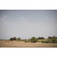 Un camion porteur polyvalent lourd de dépannage (PPLD) tracte un véhicule de l'avant blindé (VAB) enlisé dans la boue près d'Ayorou, au Niger.