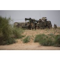 Un camion porteur polyvalent lourd de dépannage (PPLD) tracte un véhicule de l'avant blindé (VAB) enlisé dans la boue près d'Ayorou, au Niger.