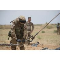 Un soldat détend le treuil de la grue d'un porteur polyvalent lourd de dépannage (PPLD) au terme d'un dépannage près d'Ayorou, au Niger.